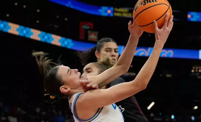 UCLA guard Gabriela Jaquez (11) grabs a rebound over South Carolina guard Tessa Johnson (5) during the second half of the women's National Championship Final Four NCAA college basketball tournament game, Sunday, April 5, 2026, in Phoenix. (AP Photo/Ross D. Franklin)