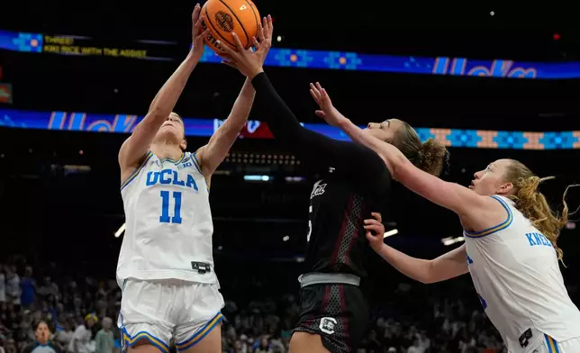 UCLA guard Gabriela Jaquez (11) grabs a rebound over South Carolina guard Tessa Johnson (5) during the second half of the women's National Championship Final Four NCAA college basketball tournament game, Sunday, April 5, 2026, in Phoenix. (AP Photo/Ross D. Franklin)