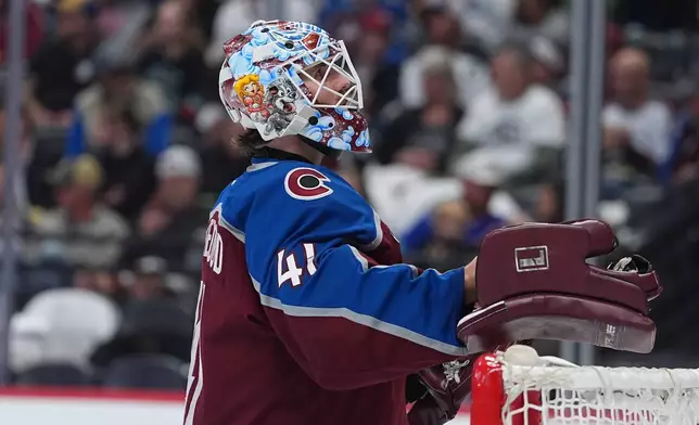 Colorado Avalanche goaltender Scott Wedgewood pulls on his gloves in the second period of an NHL hockey game against the Seattle Kraken, Thursday, April 16, 2026, in Denver. (AP Photo/David Zalubowski)