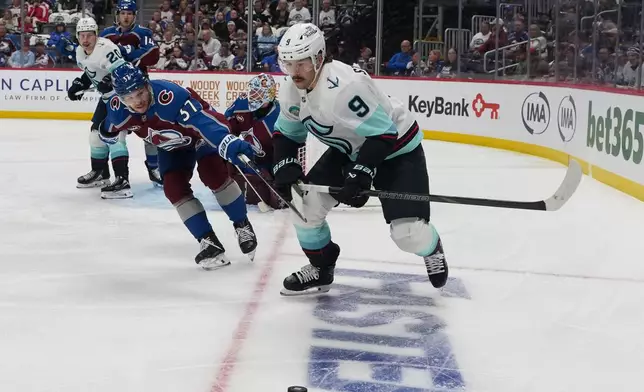 Seattle Kraken center Chandler Stephenson (9) pursues the puck with Colorado Avalanche defenseman Nick Blankenburg (37) in the second period of an NHL hockey game Thursday, April 16, 2026, in Denver. (AP Photo/David Zalubowski)