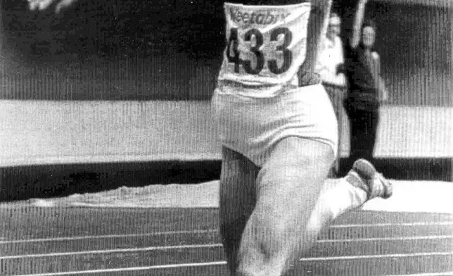 FILE - A happy Marita Koch of East Germany raises her arms in victory after crossing the finish line to win the 400-metre event at the World Cup of Athletics in Montreal, Canada, Aug. 26, 1979. (AP PhotoStaff/Drew, File)