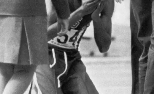 FILE - Bob Beamon of El Paso, Tex., sobs into his hands in joy on Oct. 18, 1968 at the Olympic track stadium in Mexico City. (AP Photo, File)