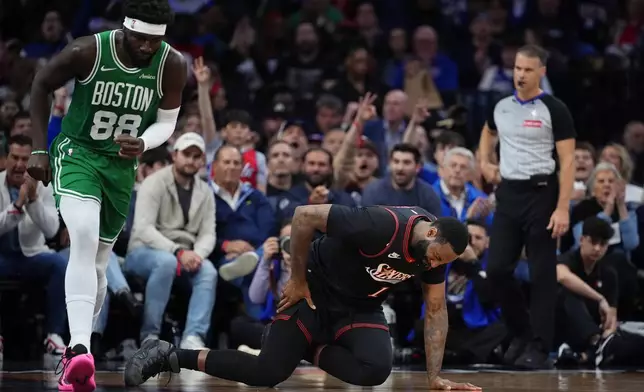 Philadelphia 76ers' Andre Drummond, right, reacts past Boston Celtics' Neemias Queta after an injury during the first half of Game 4 in a first-round NBA basketball playoffs series Sunday, April 26, 2026, in Philadelphia. (AP Photo/Matt Slocum)
