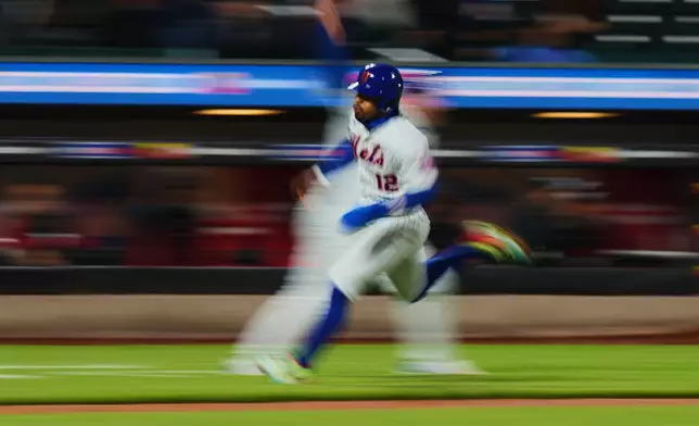 New York Mets' Francisco Lindor (12) runs toward home plate to score on a double by Francisco Alvarez during the fourth inning of a baseball game against the Minnesota Twins Wednesday, April 22, 2026, in New York. (AP Photo/Frank Franklin II)