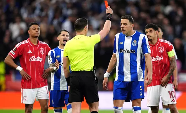 Porto's Jan Bednarek, center, is shown a red card and sent off by referee Danny Makkelie during the Europa League quarterfinal second leg soccer match between Nottingham Forest and Porto in Nottingham, England, Thursday April 16, 2026. (Martin Rickett/PA via AP)
