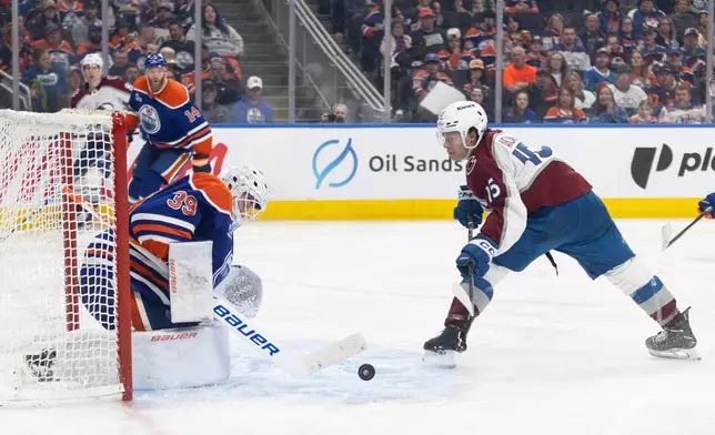 Colorado Avalanche's Jack Ahcan (15) is stopped by Edmonton Oilers goalie Connor Ingram (39) during third period NHL action, in Edmonton on Monday, April 13, 2026. (Jason Franson/The Canadian Press via AP)