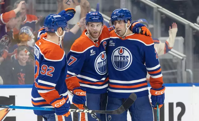 Edmonton Oilers' Vasily Podkolzin (92), Connor McDavid (97) and Evan Bouchard (2) celebrate after a goal against the Colorado Avalanche during second-period NHL hockey game action in Edmonton,Alberta, Monday, April 13, 2026. (Jason Franson/The Canadian Press via AP)
