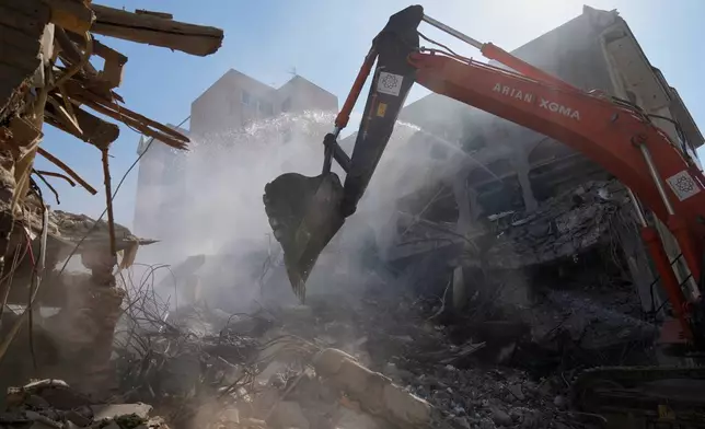 FILE - An excavator removes rubble at the site of a strike that, according to a security official at the scene, destroyed half of the Khorasaniha Synagogue and nearby residential buildings in Tehran, Iran, Tuesday, April 7, 2026. (AP Photo/Francisco Seco, File)