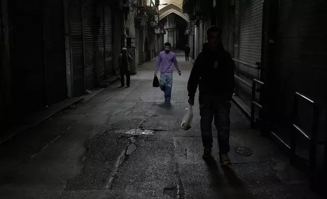 FILE - People walk past closed shops at the nearly empty traditional main bazaar during Iranian New Year, or Nowruz, holidays in Tehran, Iran, Sunday, March 29, 2026. (AP Photo/Vahid Salemi, File)