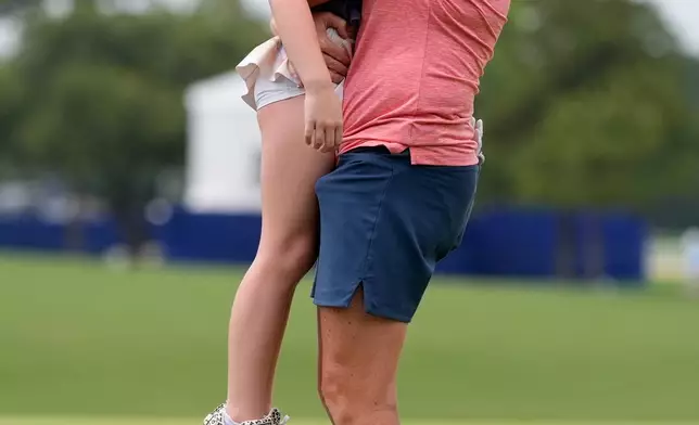 Stacy Lewis is greeted by her daughter Chesnee on the 18th green after the second round of the Chevron Championship LPGA golf tournament Friday, April 24, 2026, in Houston. (AP Photo/Ashley Landis)