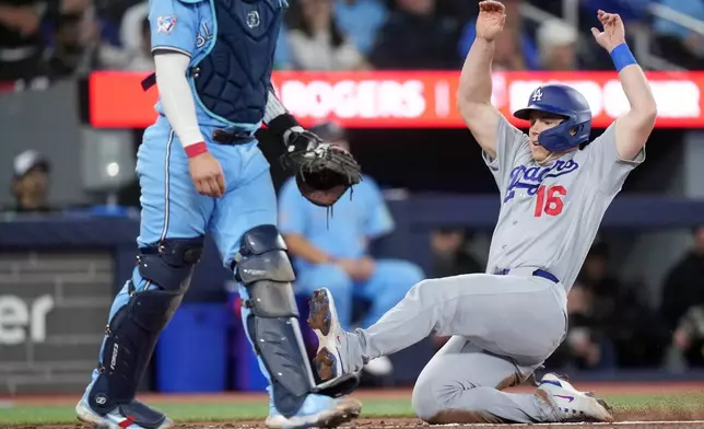 Los Angeles Dodgers Will Smith (16) slides into home plate for a run against the Toronto Blue Jays during the fourth inning of a baseball game in Toronto, Wednesday, April 8, 2026. (Nathan Denette/The Canadian Press via AP)