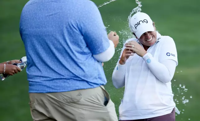 Lauren Coughlin gets sprayed with water after winning the Aramco Championship golf tournament Sunday, April 5, 2026, in North Las Vegas, Nev. (AP Photo/Ian Maule)