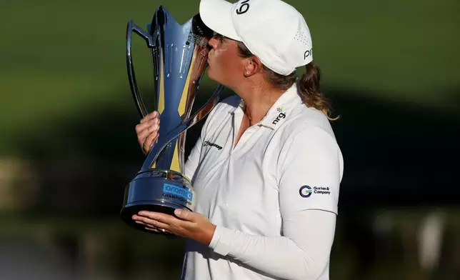 Lauren Coughlin kisses the trophy after winning the Aramco Championship golf tournament Sunday, April 5, 2026, in North Las Vegas, Nev. (AP Photo/Ian Maule)