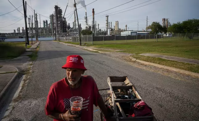 Gavino Rivera talks about the decline of the Hillcrest neighborhood Thursday, Nov. 16, 2023, as he gathers scrap metal near a Citgo oil refinery in Corpus Christi, Texas. (Jon Shapley/Houston Chronicle via AP)