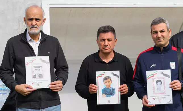 FILE - Iran's coach Amir Ghalenoei, center, and Iran's Football Federation Vice President Mehdi Mohammad Nabi, left, hold pictures of children allegedly killed in a U.S. and Israel strikes in Iran, before an international friendly soccer match between Iran and Costa Rica, in Antalya, southern Turkey, Tuesday, March 31, 2026. (AP Photo/Riza Ozel, File)