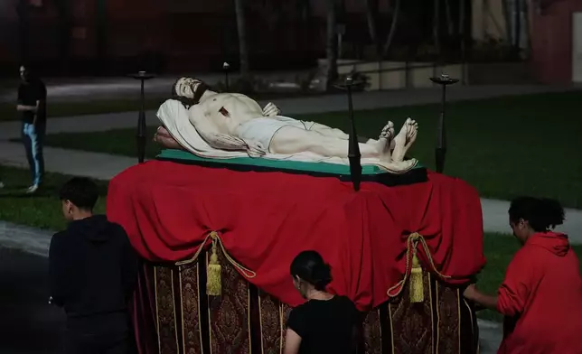 Corpus Christi Catholic Church youth group members push a float with Jesus during a rehearsal for their Good Friday procession Monday, March 23, 2026, in Miami, Fla. (AP Photo/Marta Lavandier)