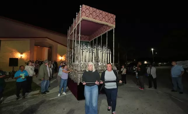 Corpus Christi Catholic Church members push a large float that will carry the Lady of Hope Macarena during a rehearsal for their Good Friday procession, Monday, March 23, 2026, in Miami, Fla. (AP Photo/Marta Lavandier)