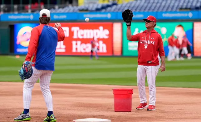 Philadelphia Phillies interim manager Don Mattingly, right, warms up with Bryce Harper before a baseball game against the San Francisco Giants Tuesday, April 28, 2026, in Philadelphia. (AP Photo/Matt Slocum)