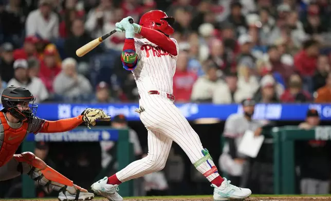 Philadelphia Phillies' Bryce Harper follows through after hitting a run-scoring double against San Francisco Giants pitcher Tyler Mahle during the sixth inning of a baseball game Tuesday, April 28, 2026, in Philadelphia. (AP Photo/Matt Slocum)