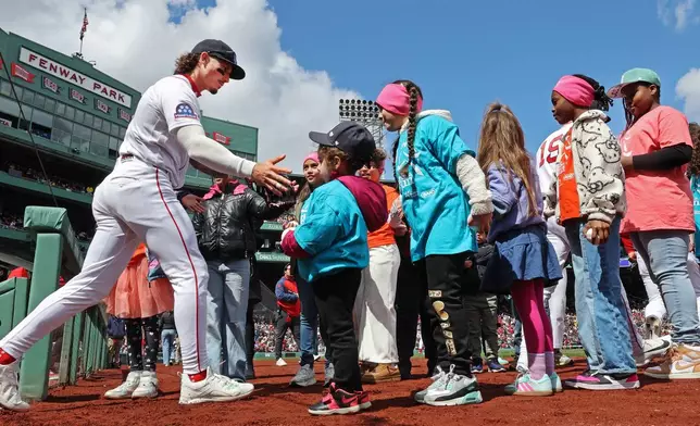 Boston Red Sox' outfielder Jarren Duran runs a gauntlet of young fans as he heads onto the field for the start of a baseball game against the Detroit Tigers, Monday, April 20, 2026 in Boston. (AP Photo/Jim Davis)