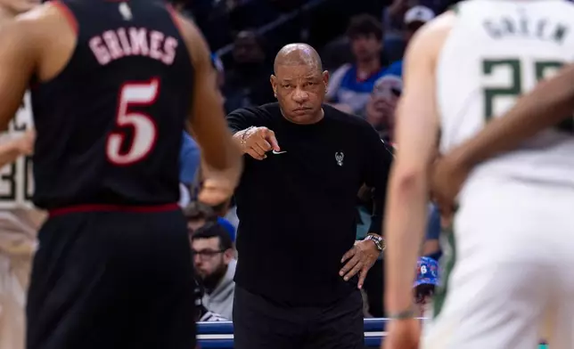 Milwaukee Bucks head coach Doc Rivers, center, directs his team from the sideline during the first half of an NBA basketball game against the Philadelphia 76ers, Sunday, April 12, 2026, in Philadelphia. (AP Photo/Chris Szagola)