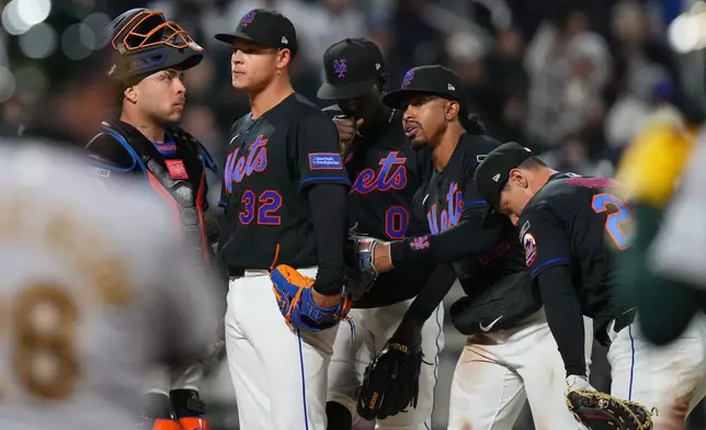 New York Mets' Francisco Lindor, right, and Francisco Alvarez, left, encourae pitcher Tobias Myers (32) before he leaves during the ninth inning of a baseball game against the Athletics Friday, April 10, 2026, in New York. (AP Photo/Frank Franklin II)