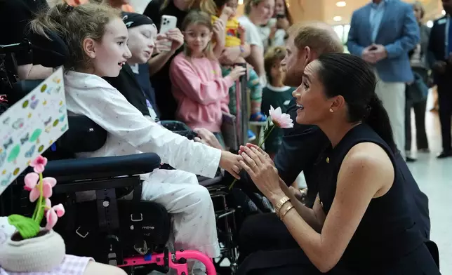 Britain's Prince Harry and Meghan Markle, the Duke and Duchess of Sussex, meet patients and their family members during a visit to the Royal Children's Hospital Melbourne, Australia Tuesday, April 14, 2026. (Jonathan Brady/Pool Photo via AP)