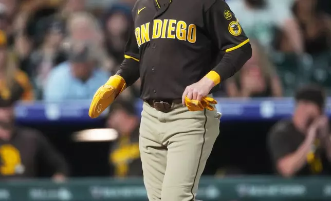 San Diego Padres' Jake Cronenworth crosses home plate after Manny Machado earned a walk with the bases loaded from Colorado Rockies relief pitcher Chase Dollander in the sixth inning of a baseball game Tuesday, April 21, 2026, in Denver. (AP Photo/David Zalubowski)