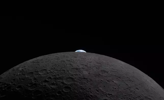 In this image provided by NASA, the Artemis II crew photographed the Earth peeking out over the horizon of the Moon on Monday, April 6, 2026. (NASA via AP)