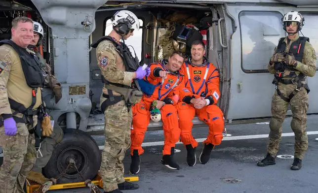 In this photo provided by NASA, The Artemis II astronauts Reid Wiseman, commander and CSA (Canadian Space Agency) astronaut Jeremy Hansen, are photographed on the flight deck of USS John P. Murtha after they were extracted from their Orion spacecraft after splashdown on Friday, April 11, 2026. (NASA via AP)