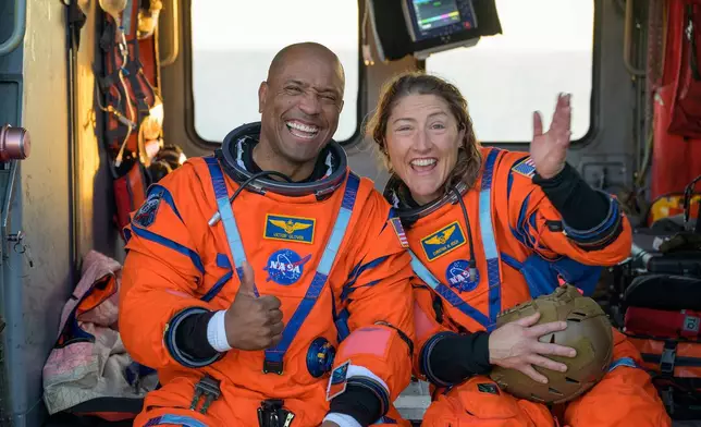 In this photo provided by NASA, the Artemis II astronauts Victor Glover and Christina Koch are photographed on the flight deck of USS John P. Murtha after they were extracted from their Orion spacecraft after splashdown on Friday, April 11, 2026. (NASA via AP)