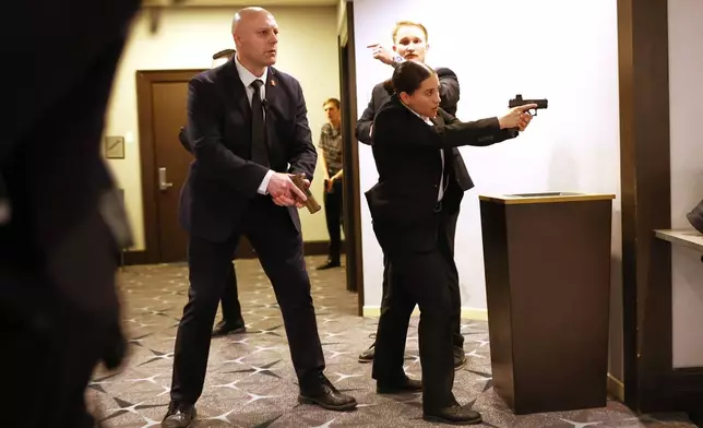 Members of law enforcement respond during the White House Correspondents Dinner, Saturday, April 25, 2026, in Washington. (AP Photo/Tom Brenner)