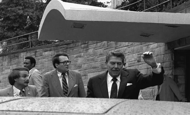 FILE - President Ronald Reagan winces and raises his left arm as he was shot by an assailant as he left a Washington hotel, Monday, March 30, 1981. (AP Photo/Ron Edmonds, File)