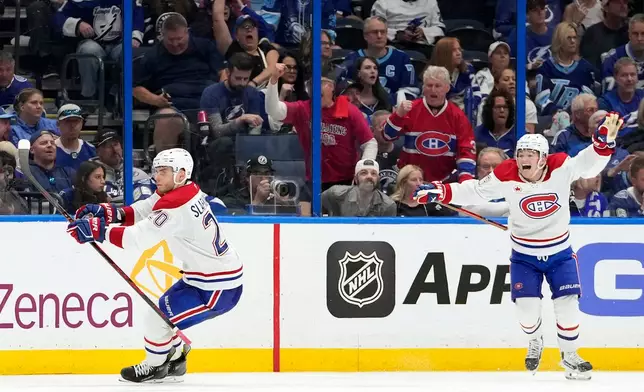 Montréal Canadiens left wing Juraj Slafkovský (20) celebrates his goal with right wing Cole Caufield against the Tampa Bay Lightning during overtime in Game 1 of an NHL hockey Stanley Cup first-round playoff series, Sunday, April 19, 2026, in Tampa, Fla. (AP Photo/Chris O'Meara)