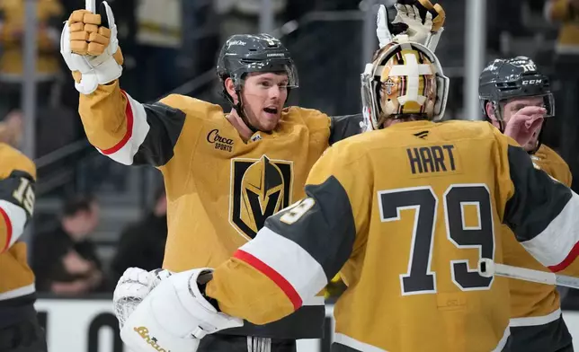 Vegas Golden Knights defenseman Jeremy Lauzon, left, celebrates with Vegas Golden Knights goaltender Carter Hart (79) after defeating the Utah Mammoth in Game 1 of a first-round NHL hockey Stanley Cup playoff series Sunday, April 19, 2026, in Las Vegas. (AP Photo/John Locher)