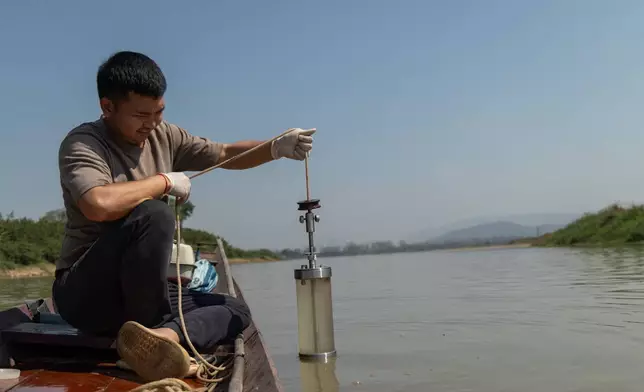 Researcher Khanasuan Kaeothip takes a water sample from the Kok River, in Chiang Saen, Thailand, on Feb. 17, 2026. (AP Photo/Anton L. Delgado)