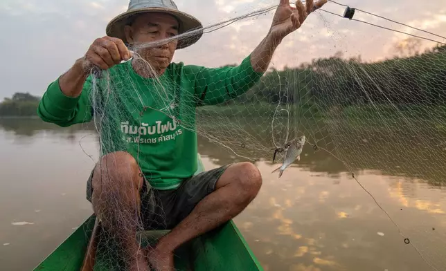 Fisherman Sukjai Yana catches a small fish from the Kok River in Chiang Saen, Thailand, Sunday, Feb. 22, 2026. (AP Photo/Anton L. Delgado)