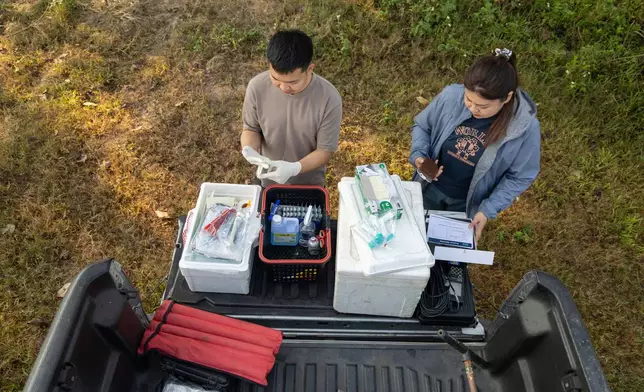 Researchers Khanasuan Kaeothip, left, and Warakorn Maneechuket prepare to take samples from the Kok River in Chiang Saen, Thailand, Tuesday, Feb. 17, 2026. (AP Photo/Anton L. Delgado)