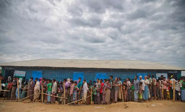 FILE -Rohingya Muslims, who crossed over from Myanmar into Bangladesh, wait in queues to receive aid at Kutupalong refugee camp in Ukhiya, Bangladesh, Nov. 15, 2017. (AP Photo/A.M. Ahad, File)