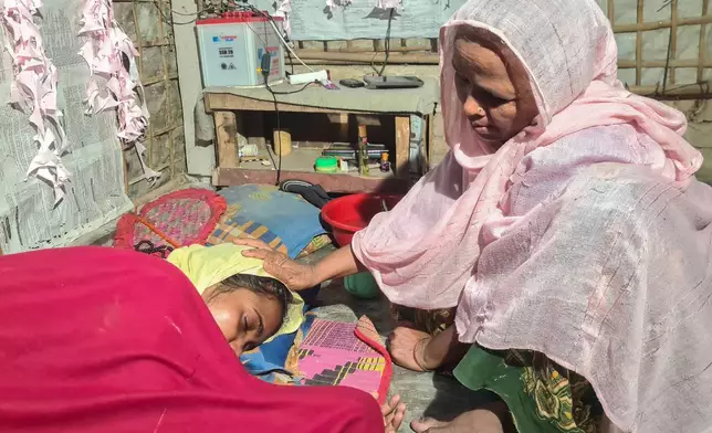 Majuma Khatun, the mother of Rahela Begum, a Rohingya survivor, comforts her at their shelter after she was rescued on April 9, 2026 from a capsized boat, at a refugee camp in Cox's Bazar, Bangladesh, Wednesday, April 15, 2026. (AP Photo/Suzauddin Rubel)