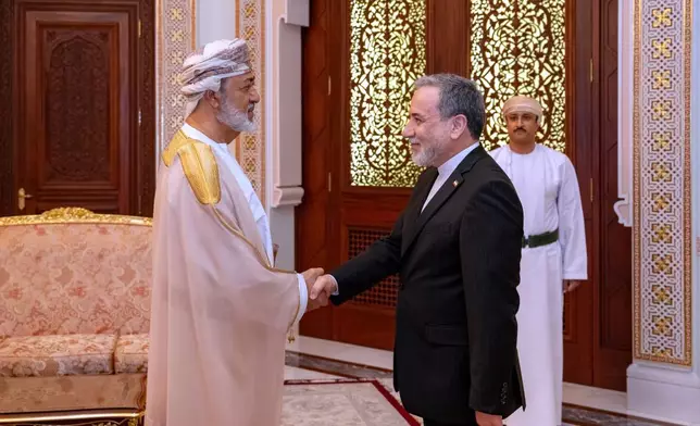 In this photo released by the Iranian Foreign Ministry, Iranian Foreign Minister Abbas Araghchi, right, shakes hands with Oman's Sultan Haitham bin Tariq during their meeting, in Muscat, Oman, Sunday, April 26, 2026. (Iranian Foreign Ministry via AP)