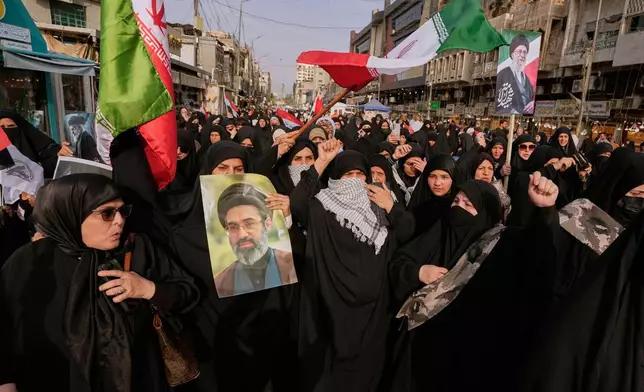 Iraqis Muslim women hold portraits of Iran's late Supreme Leader Ayatollah Ali Khamenei and his son Ayatollah Mojtaba Khamenei, during a protest against U.S. and Israeli attacks on multiple cities across Iran, in Baghdad, Iraq, Saturday, April 25, 2026. (AP Photo/Hadi Mizban)