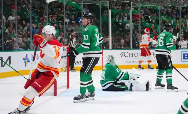 Dallas Stars goaltender Jake Oettinger, center, reacts after giving up a goal to Calgary Flames center Martin Pospisil, second from right, during the second period of an NHL hockey game Tuesday, April 7, 2026, in Dallas. (AP Photo/Julio Cortez)
