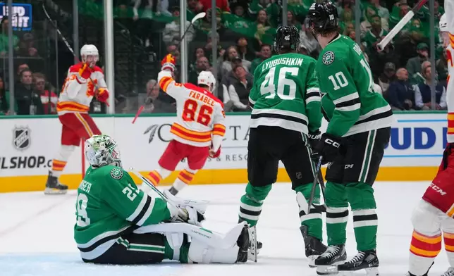 Calgary Flames left wing Joel Farabee (86) reacts after scoring a goal on Dallas Stars goaltender Jake Oettinger (29) during the second period of an NHL hockey game Tuesday, April 7, 2026, in Dallas. (AP Photo/Julio Cortez)