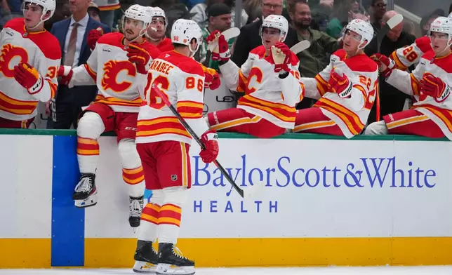 Calgary Flames left wing Joel Farabee (86) skates by his bench after scoring a goal against the Dallas Stars during the second period of an NHL hockey game Tuesday, April 7, 2026, in Dallas. (AP Photo/Julio Cortez)