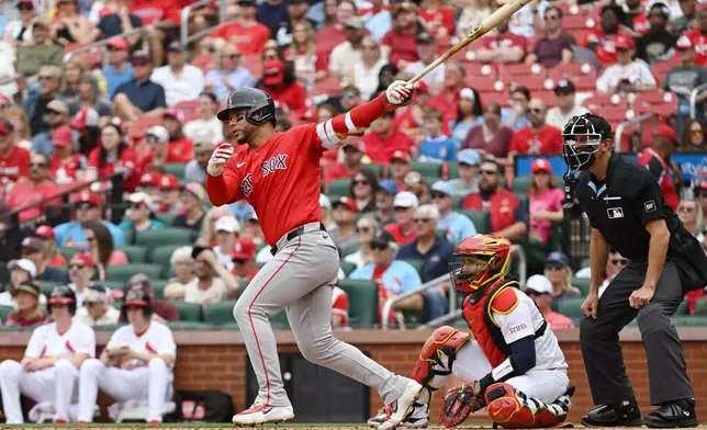 Boston Red Sox's Willson Contreras, left, hits a single in the third inning of a baseball game against the St. Louis Cardinals, Sunday, April 12, 2026, in St. Louis. (AP Photo/Michael Thomas)