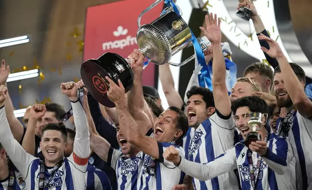 Real Sociedad's Mikel Oyarzabal, centre, lifts the trophy after the Copa del Rey final soccer match between Atletico Madrid and Real Sociedad in Seville, Spain, Saturday, April. 18, 2026. (AP Photo/Jose Breton)