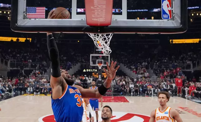 New York Knicks center Karl-Anthony Towns (32) shoots against Atlanta Hawks forward Onyeka Okongwu (17) during the first half of Game 4 in a first-round NBA playoffs basketball series Saturday, April 25, 2026, in Atlanta. (AP Photo/Brynn Anderson)