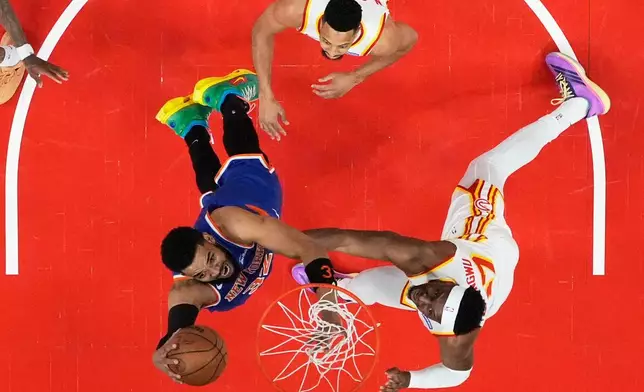 New York Knicks center Karl-Anthony Towns (32) shoots against Atlanta Hawks forward Onyeka Okongwu (17) during the first half of Game 4 in a first-round NBA playoffs basketball series Saturday, April 25, 2026, in Atlanta. (AP Photo/Brynn Anderson)