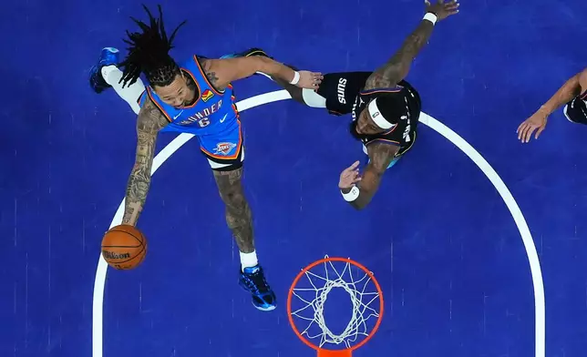 Oklahoma City Thunder forward Jaylin Williams (6) scores against Phoenix Suns forward Royce O'Neale during the second half of Game 3 of a first-round NBA playoffs basketball series, Saturday, April 25, 2026, in Phoenix. (AP Photo/Ross D. Franklin)